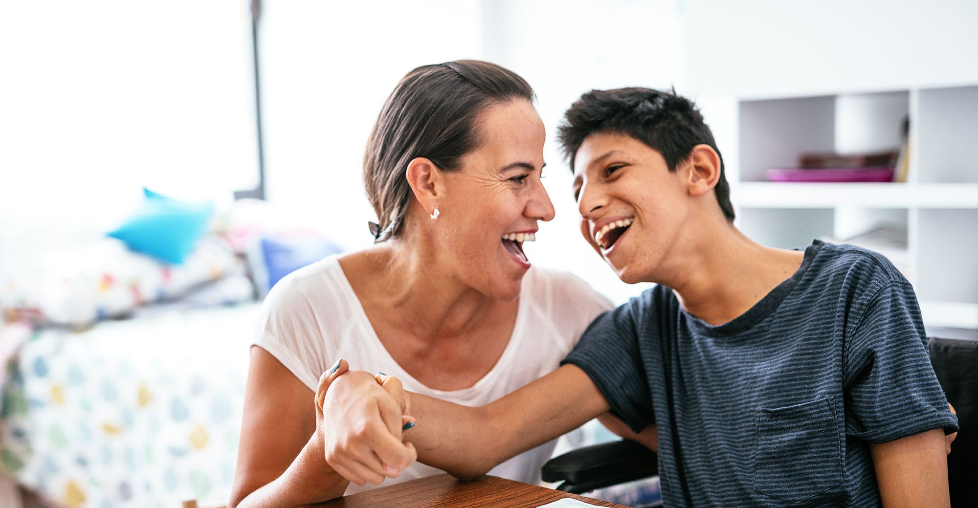 Woman and young boy laughing and coloring Woman and young boy laughing and coloring